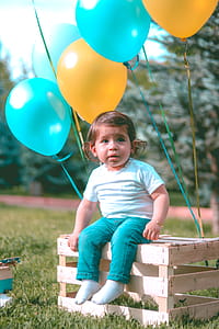 Girl Wearing White Shirt And Blue Jeans Sitting On Wooden Crate thumbnail