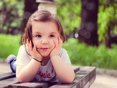 selective focus photography of girl laying on brown wooden plank table thumbnail