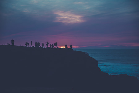 silhouette of people standing on hill during sunset thumbnail