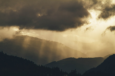 timelapse photography of mountain range under gray cloudy sky thumbnail