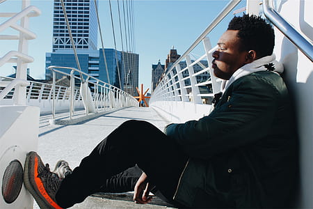 man sitting and leaning on white handrails thumbnail