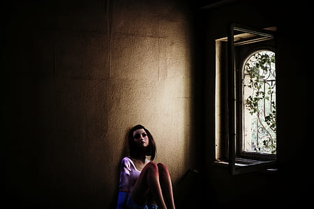 sitting woman wearing white scoop-neck top near white metal window thumbnail