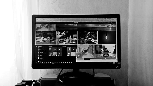 grayscale photography of turned-on computer monitor with assorted photos display thumbnail