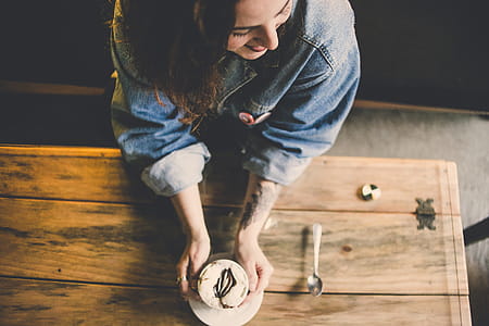 Woman Holding Cake Standing Near Table thumbnail