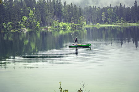 Person on Green Boat Fishing on Body of Water thumbnail
