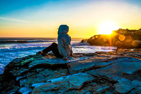 person wearing hoodie sitting on stone thumbnail