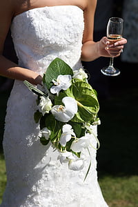 person in white straight across wedding gown holding clear flute glass thumbnail