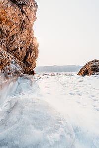 frozen body of water near mountain thumbnail