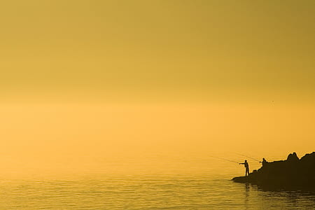 silhouette of person holding fishing rod thumbnail
