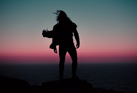 silhouette of man near body of water thumbnail