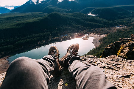 person sitting on rock cliff thumbnail