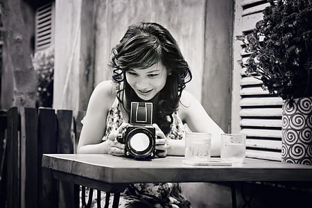 woman holding camera on table thumbnail