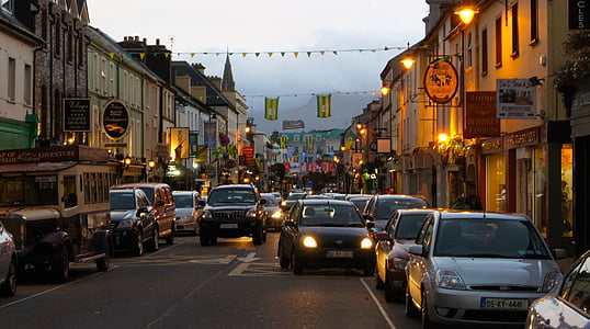 several cars on gray road beside buildings thumbnail