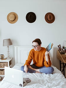 woman sitting on bed in front of MacBook thumbnail
