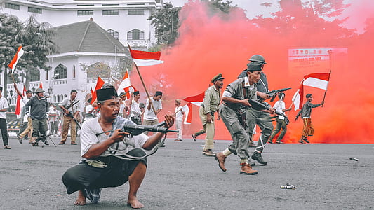 man squat while holding a gun in the middle of a day rally thumbnail