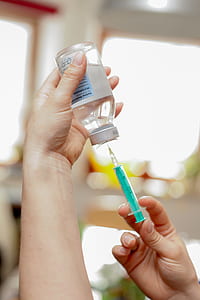 person getting clear liquid in bottle using syringe thumbnail