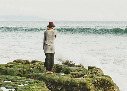 woman standing on rock on seashore thumbnail