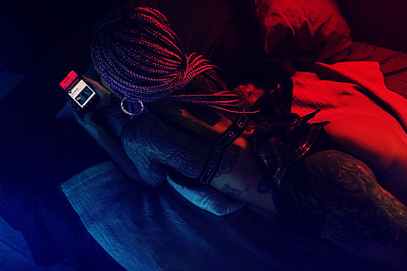 woman using smartphone while lying in bed thumbnail
