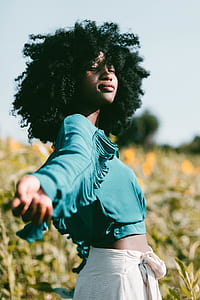 shallow focus photography of woman in blue crop top on flower field during daytime thumbnail