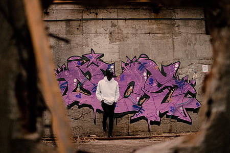 man leaning on graffiti wall thumbnail