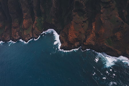 birds eye photography of brown mountain and body of water thumbnail