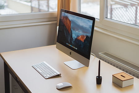 iMac set on brown wooden table thumbnail