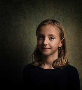 smiling girl with black shirt near wall in dimmed room thumbnail