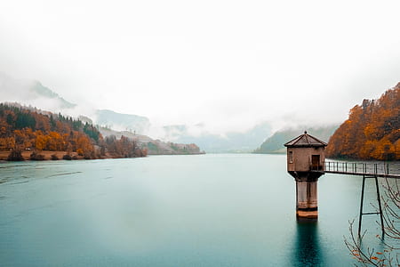 beige concrete gazebo dock surrounded by mountains and forest thumbnail