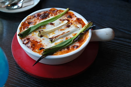 photo of round white bowl filled with sauce and onion leaks thumbnail