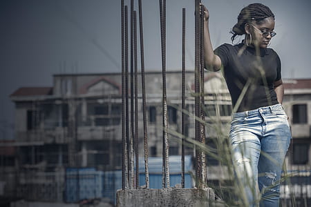 Woman Standing While Holding Corroded Brown Bar Outdoors thumbnail