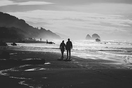 two person walking along shoreline while holding hands thumbnail