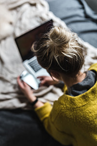 Blond using her laptop at her bedroom thumbnail