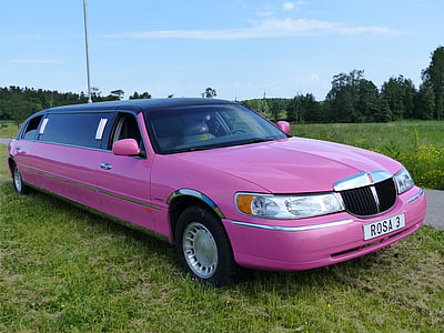 pink Lincoln Town Car limousin parked on grass thumbnail