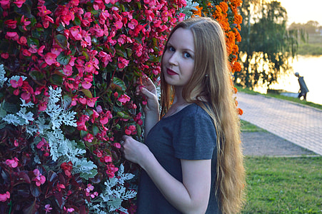 woman standing near pink petaled flowers thumbnail