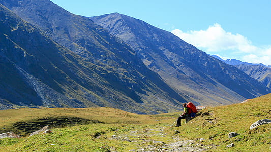 man sitting on green green grass under white sky thumbnail