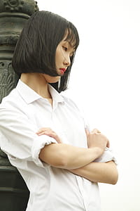 Woman Wearing White Dress Shirt Standing Near Concrete Statue thumbnail