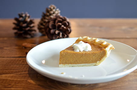 pie on white plate and pine cones closeup photo thumbnail