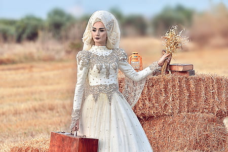 woman wearing white wedding gown holding flowers and wooden case thumbnail