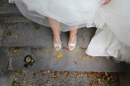person in white wedding gown and silver sandals thumbnail