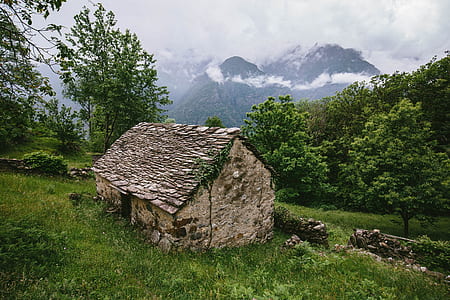 brown concrete house on green grass field thumbnail