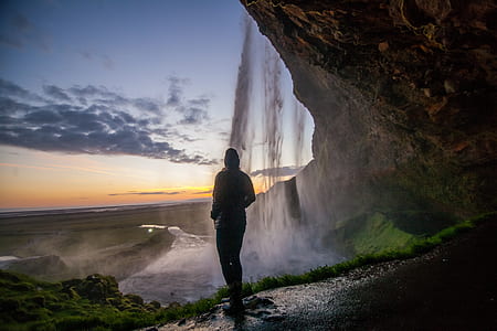 person standing under waterfalls thumbnail