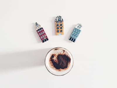 cup of coffee and three house figurines thumbnail