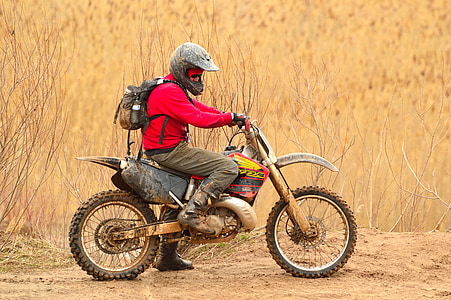 man in red jacket and grey pants riding on dirt bike thumbnail
