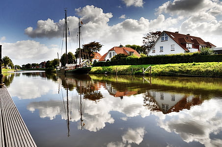 boat sailed near house during daytime thumbnail