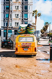 yellow Volkswagen Kombi with surfboard on roof thumbnail