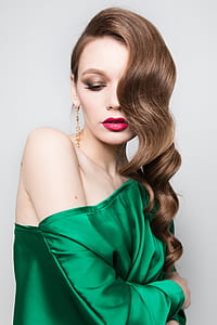 woman wearing gold earrings and green blouse thumbnail