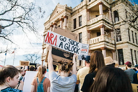 woman showing signage together with people rallying thumbnail
