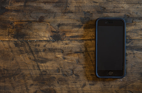 space grey iPhone 6 with black case turned off on brown wooden board thumbnail