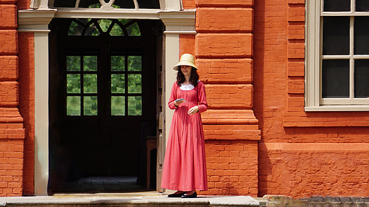 woman standing in front of the building near the door thumbnail