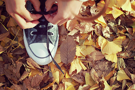 person tying black and white Converse All Star sneaker thumbnail